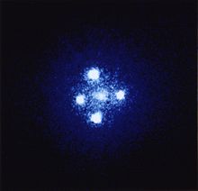 Five balls of light are arranged in a cross shape.