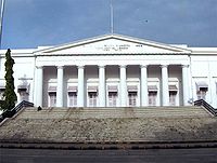 A white building with a triangular façade and wide stairs