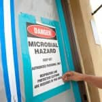 home health hazard inspector hanging a warning sign on a door