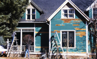 Front of dilapidated home with remodeling equipment in yard