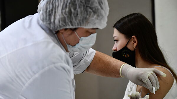 Девушка делает прививку в пункте вакцинации от коронавируса Covid-19