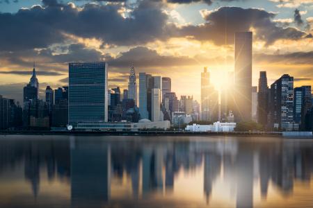 The skyline of New York City reflected in the water.