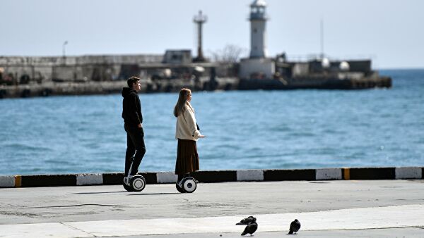 Молодые люди катаются на набережной в Ялте