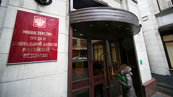 Женщина заходит в здание Министерства труда и социальной защиты Российской Федерации в Москве