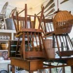 some wooden antique chairs stacked on a table 