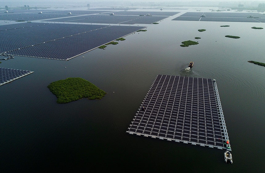 A boat pulls solar panels on a lake in Huainan