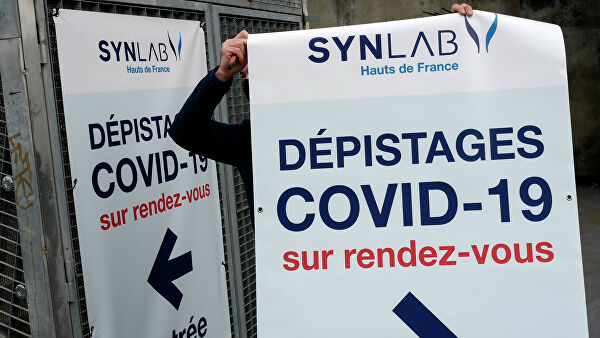 Мужчина вешает плакат с информацией о тестировании на COVID-19 на арене Lille Zenith Arena в Лилле, Франция