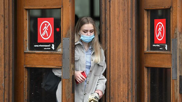 Женщина в маске выходит из метро в Москве 