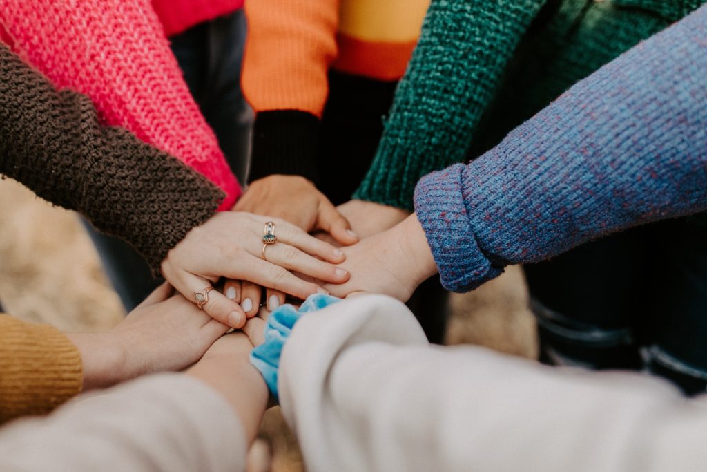 people with their hands in the middle of a circle together