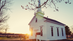 Small white church at sunrise in winter.