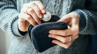 Woman holding money and purse