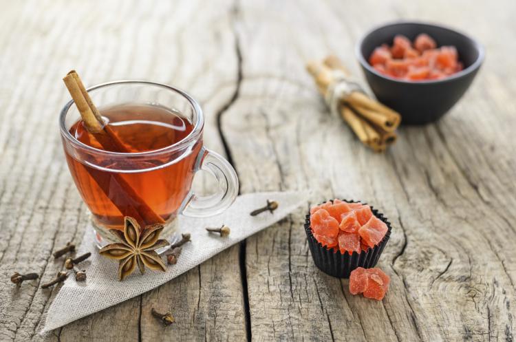 Hot mulled cider in a cup with mulling spices.