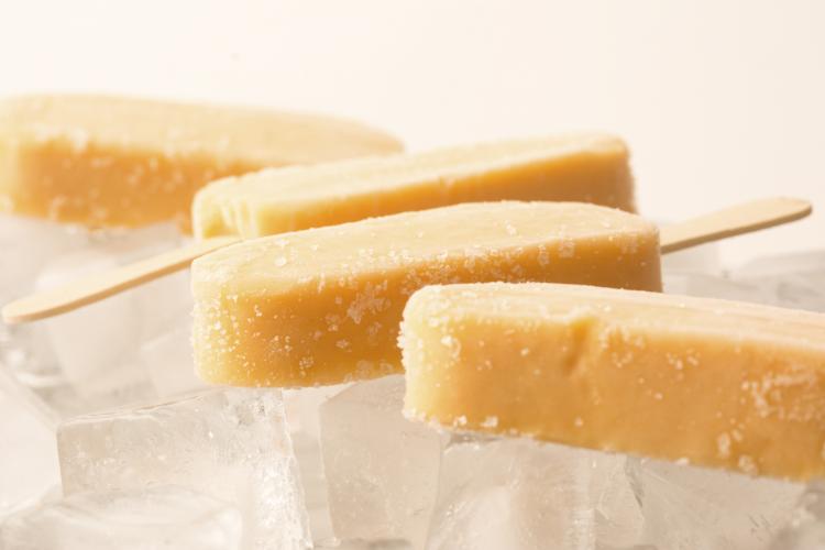 Banana, mango, and yogurt creamsicles on ice.