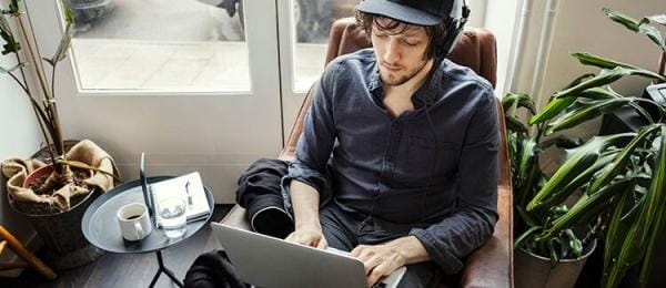 Man with headphones staring at laptop screen