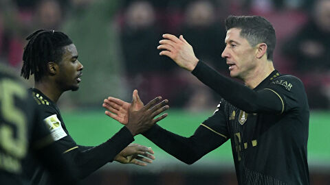 Bayern Munich's Polish forward Robert Lewandowski celebrates scoring the 2-1 with his teammate Bayern Munich's English defender Omar Richards (L) during the German first division Bundesliga football match FC Augsburg v FC Bayern Munich in Augsburg, southern Germany, on November 19, 2021. (Photo by Christof STACHE / AFP) / DFL REGULATIONS PROHIBIT ANY USE OF PHOTOGRAPHS AS IMAGE SEQUENCES AND/OR QUASI-VIDEO / “The erroneous mention[s] appearing in the metadata of this photo by Christof STACHE has been modified in AFP systems in the following manner: [Bayern Munich's Polish forward Robert Lewandowski ] instead of [Augsburg's German midfielder Andre Hahn ]. Please immediately remove the erroneous mention[s] from all your online services and delete it (them) from your servers. If you have been authorized by AFP to distribute it (them) to third parties, please ensure that the same actions are carried out by them. Failure to promptly comply with these instructions will entail liability on your part for any continued or post notification usage. Therefore we thank you very much for all your attention and prompt action. We are sorry for the inconvenience this notification may cause and remain at your disposal for any further information you may require.”