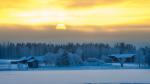 Houses and trees in the snow at dusk.