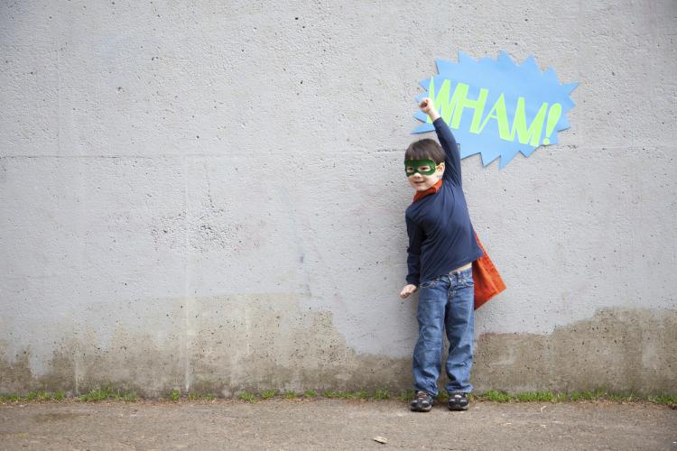 Young boy pretending to be a superhero.