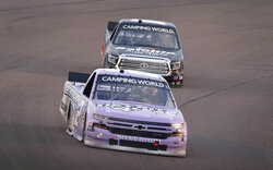 Kris Wright (2) leads Chandler Smith (18) early in the NASCAR Truck Series auto race at Phoenix Raceway on Friday, Nov. 5, 2021, in Avondale, Ariz. (AP Photo/Darryl Webb)