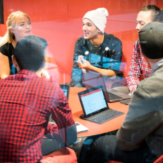 A group of people are sitting around a table having a meeting.