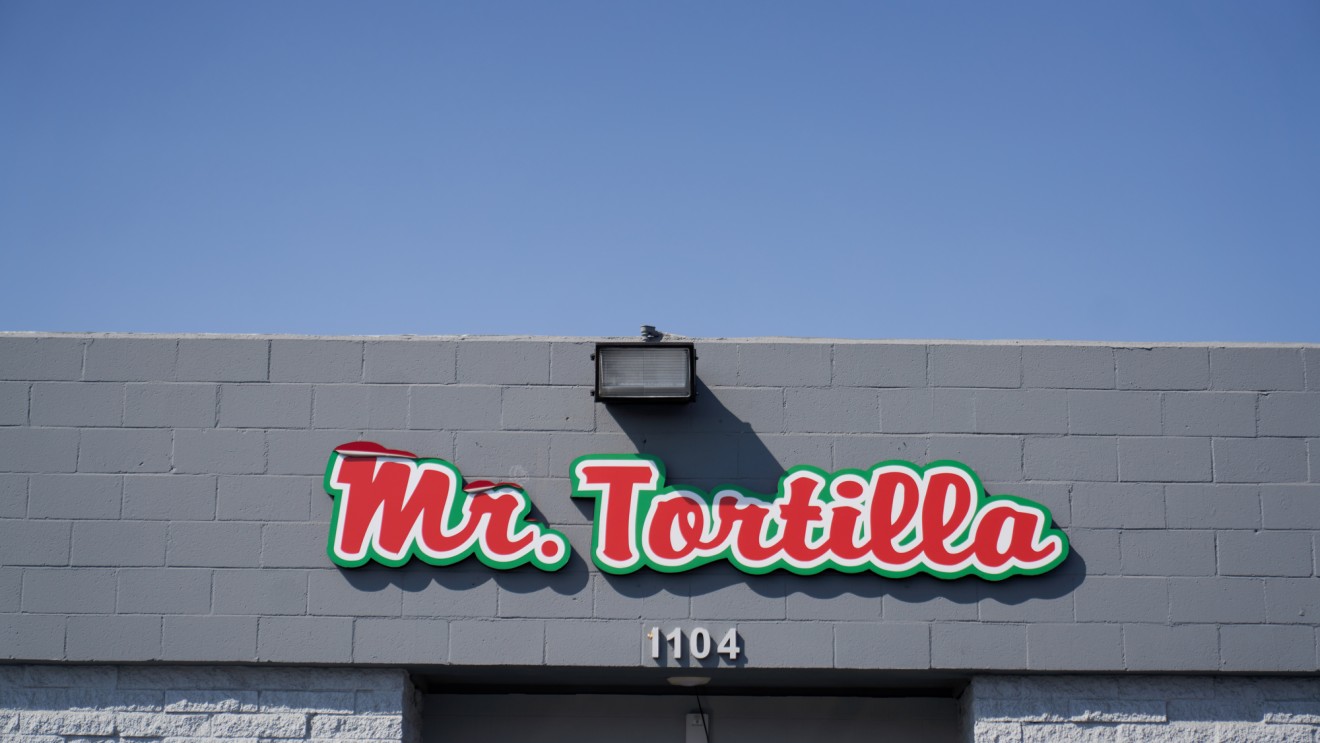 A red Mr. Tortilla sign hangs above the door of the Mr. Tortilla warehouse.