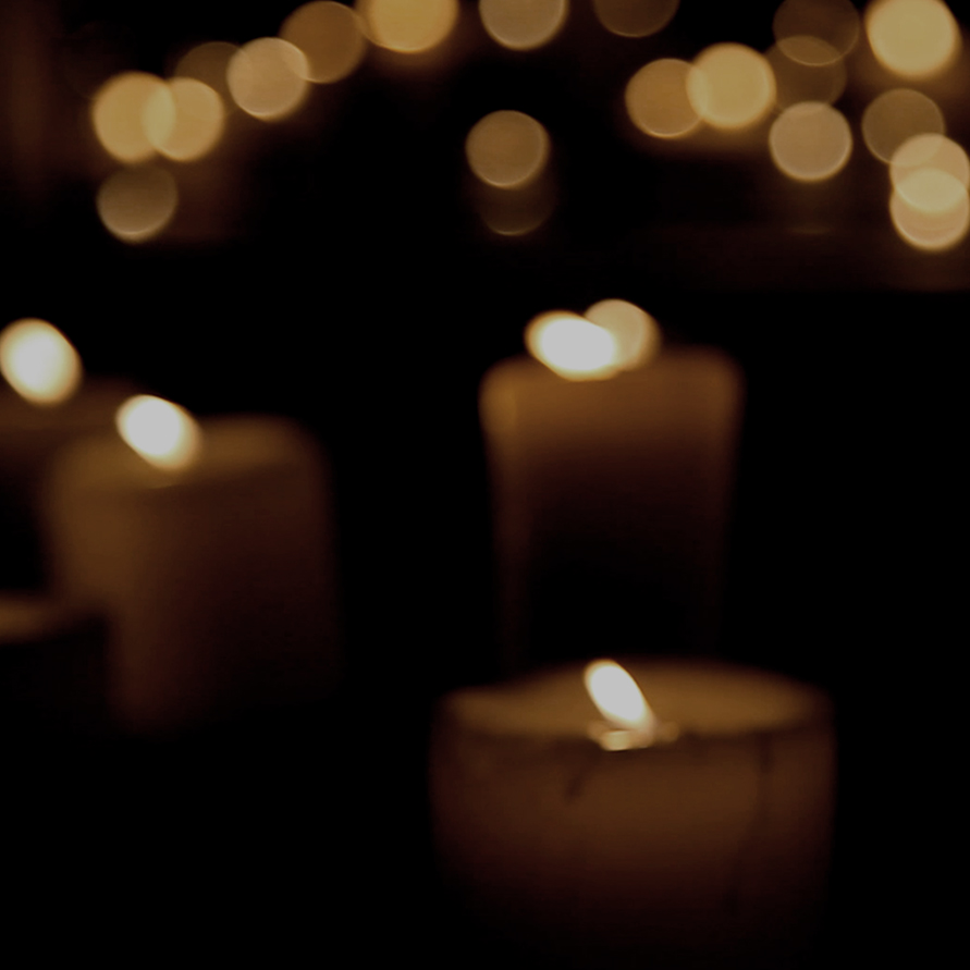 blurred image of candles for IN MEMORIAM