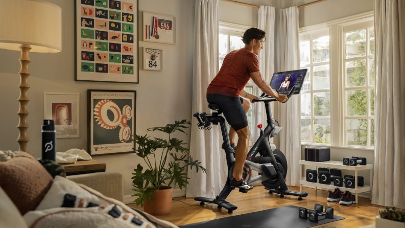 Person using an indoor stationary Peloton Bike at home