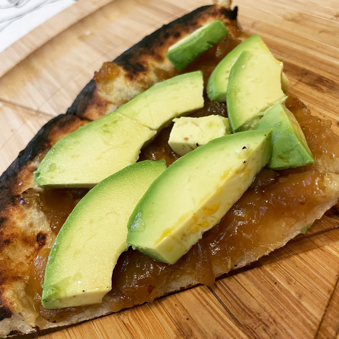 a slice of pizza sitting on top of a wooden cutting board