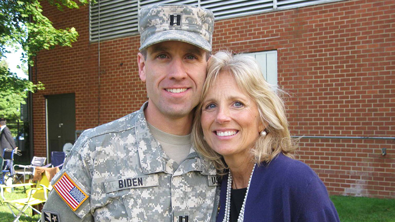 Dr. Jill Biden and Beau Biden. Beau is wearing his army fatigues, and Jill is wearing a blue sweater and pearl necklace.