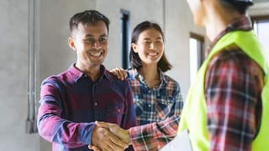 A couple shakes hands with their renovation contractor