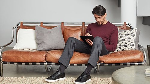 Person working on tablet sitting in a living room