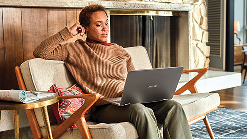 Person sitting in living room working on a laptop