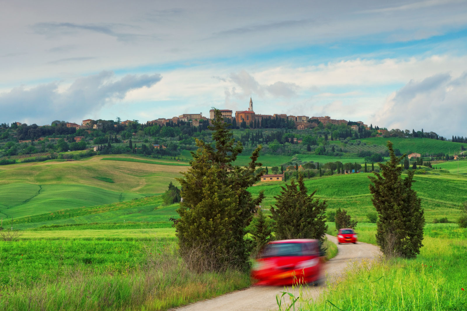 Motion blurred cars on a dirt road in Tuscany