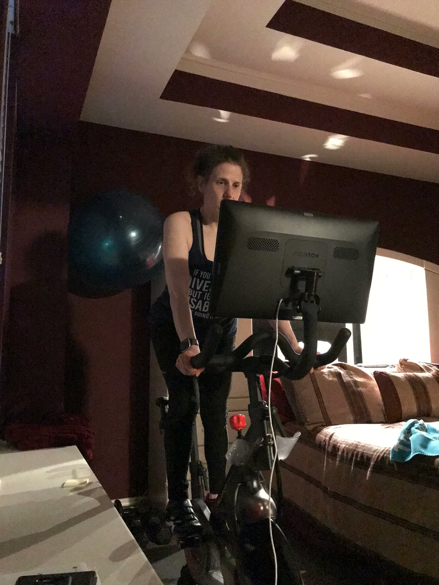 Meryl on her Peloton bike looking at the screen while working out