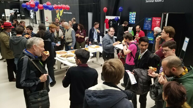 People eating free Pizza (not as in freedom) lunch at the 2019 FSFE Community Meeting at SFScon.