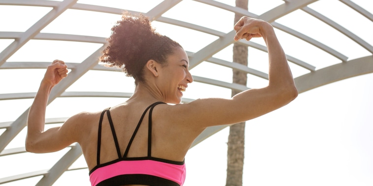 Mixed Race woman flexing arms