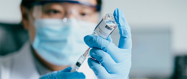 doctor pulling vaccine with siringe from vaccine bottle