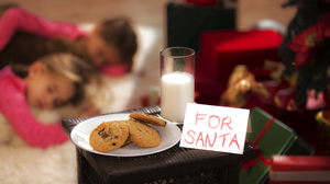 Glass of milk and plate of cookies on top of a small table. A note says 