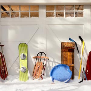 Garage with snow and sleds in front