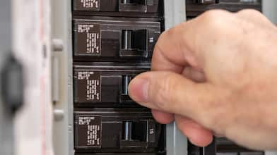 Man turning switch on circuit breaker