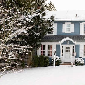 The exterior of a house during winter with snow covering the yard