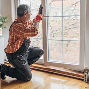Man installing new window in living room