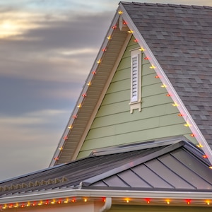 Red and yellow holiday lights decorate green house facade