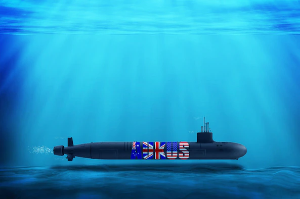 A submerged submarine with an AUKUS symbol depicting the flags of Australia, the United States, and United Kingdom.