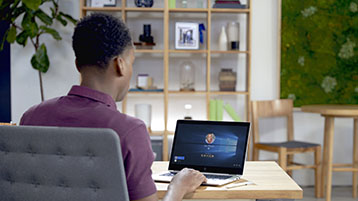 A man, working on a Windows 10 laptop