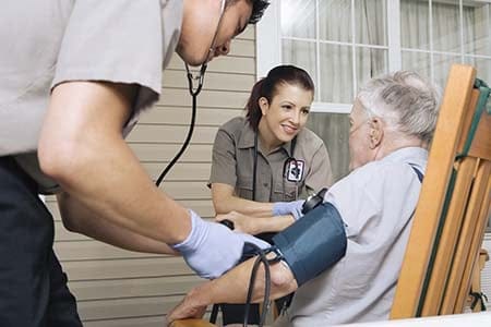 paramedics treating a patient at home