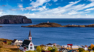 Areal view of a small coastal town with a prominent church and graveyard.