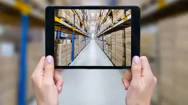 Person holding a tablet in a warehouse