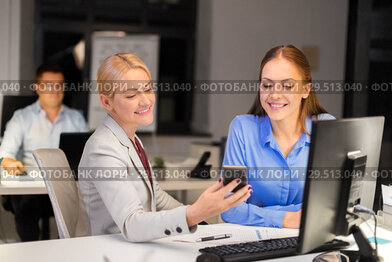 businesswomen with smartphone late at night office