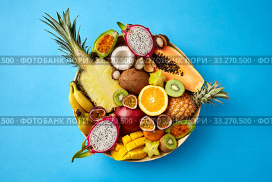 plate of exotic fruits on blue background