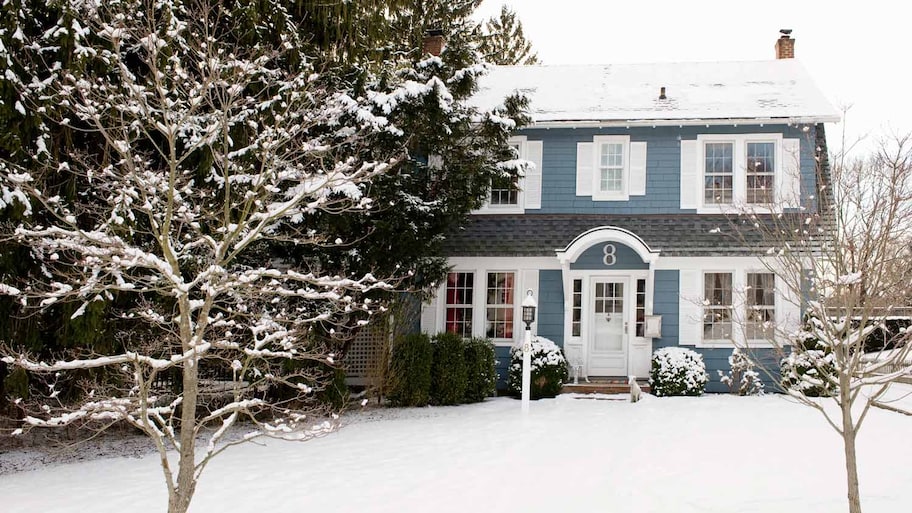 The exterior of a house during winter with snow covering the yard